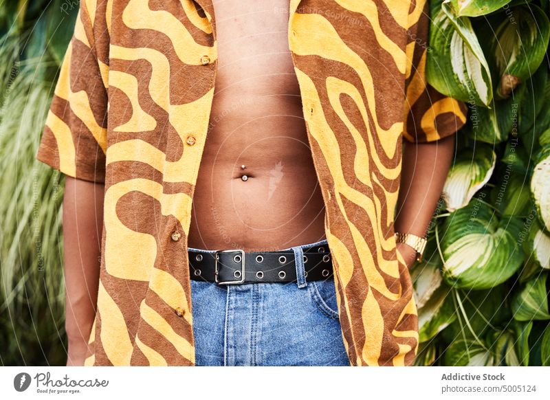 Crop male in unbuttoned shirt with soft belly man piercing bellybutton imperfection body non binary lgbt accessory ethnic flabby outfit cool belt style casual