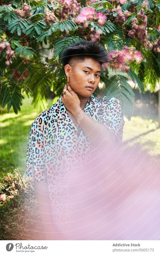 Filipino transgender woman standing on garden tree bloom lgbt non binary flower ethnic asian filipino appearance foliage queer blossom no makeup natural beauty