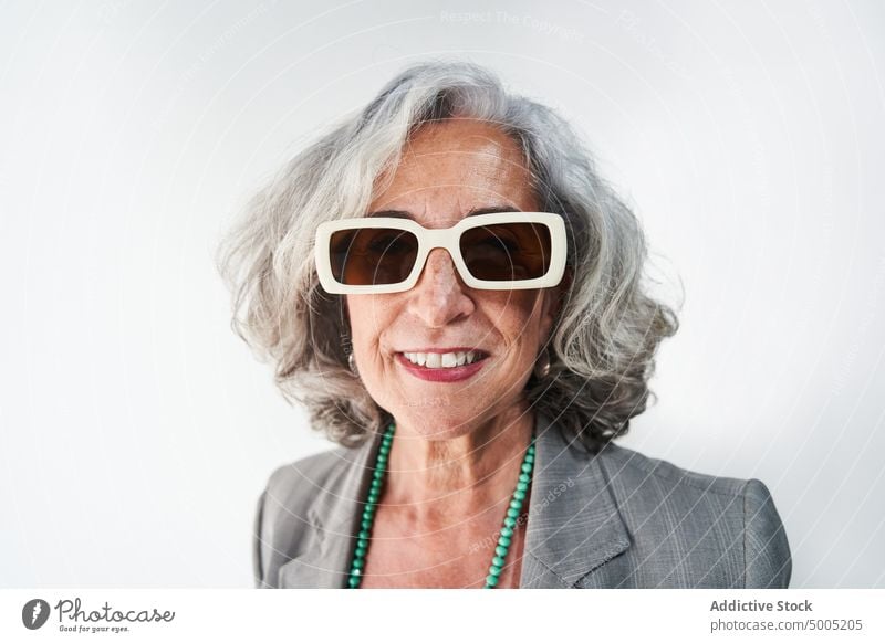 Cheerful aged woman in stylish sunglasses smile style happy appearance portrait accessory gray hair pensioner female elderly senior businesswoman glad cheerful