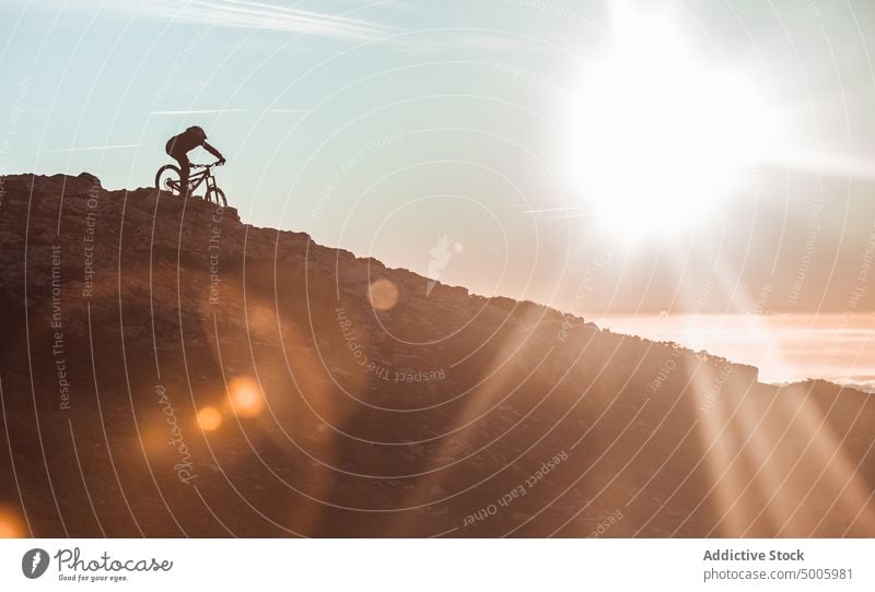 Man riding on bike on hill man helmet extreme sport mountain bicycle top guy sky sun sunshine male safety heaven adventure adrenaline mtb sunlight peak
