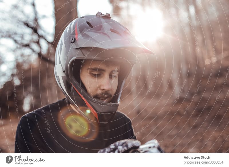Man in helmet in forest at sunset man sport active nature safety young guy extreme tree rider equipment sportsman lifestyle male speed fun travel wood sunshine