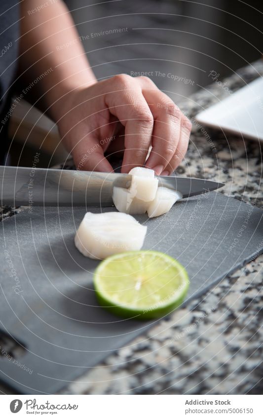 Unrecognizable chef cutting white daikon lime vegetable culinary restaurant cook cuisine kitchen citrus professional prepare dice gastronomy food occupation