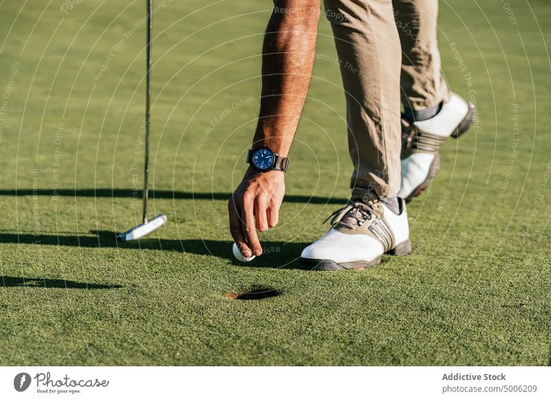 Athlete with putter and golf ball in field athlete sport prepare professional lean forward man nature golfer course player aristocratic club and ball greenery