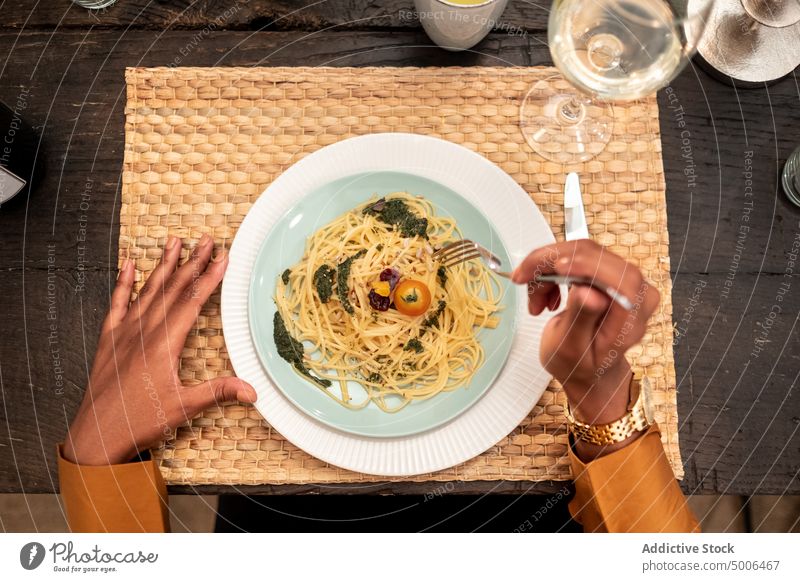 Man having dinner with friends and eating pasta food woman party hand table drink festive delicious dish meal tasty female plate tradition yummy beverage