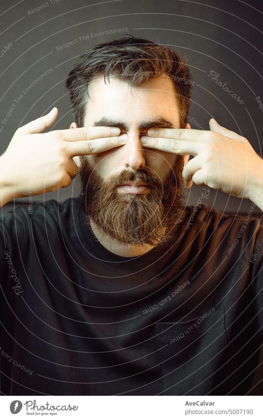 Close up portrait of healthy man with beard and black hair, strong features, looking straight.sad and depressed young man feeling upset. Human expressions and negative emotions.personality psychology.