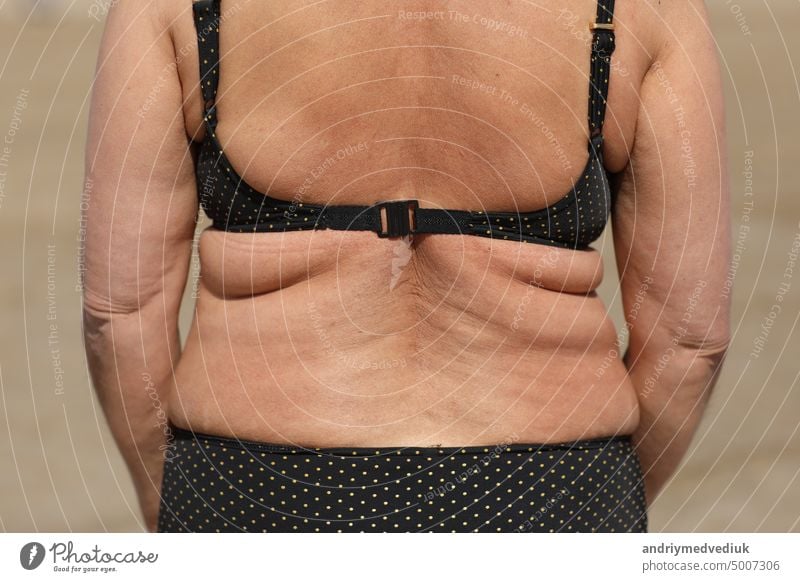 fat woman with excess weight, back view,flabby sides and back with folds of fat, overweight fat body as s result of improper diet. High quality photo care