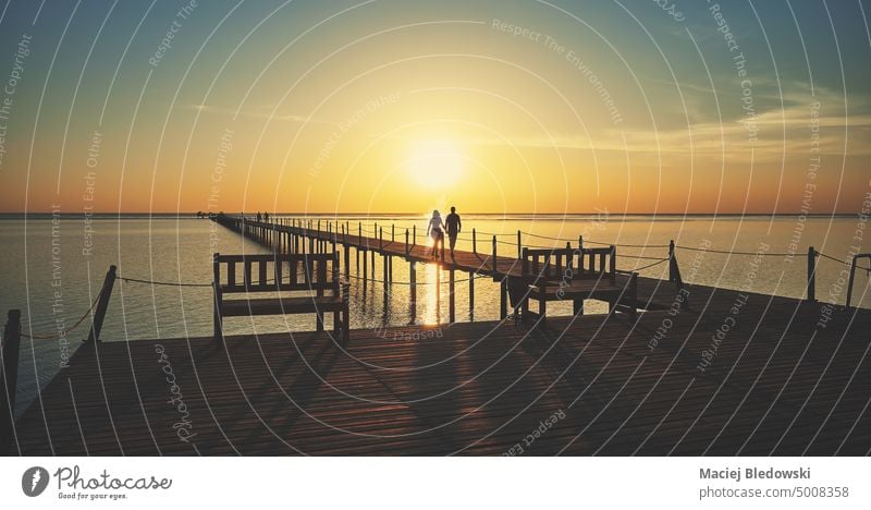 Wooden pier silhouette at sunrise, color toning applied. sea ocean water nature tranquil sky vacation horizon travel sunset retro destination scenic shore