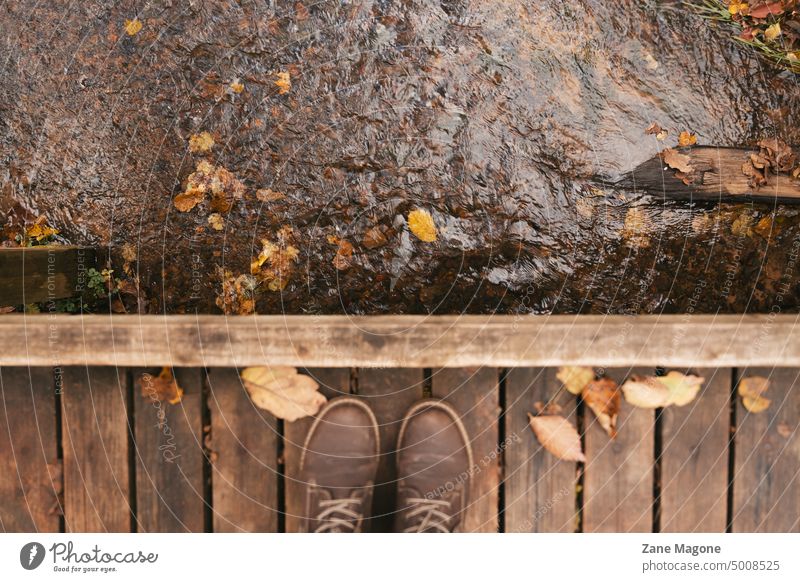 Person in hiking boots standing on wooden bridge over a stream in autumn rustic rustic lifestyle rustic aesthetic rural aesthetic aesthetic fall dreamy fall