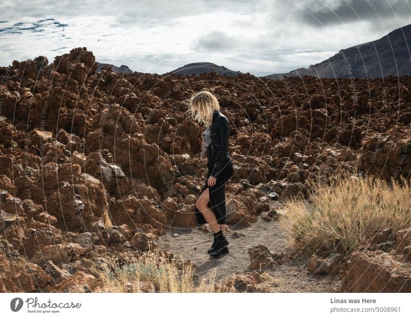 Natural beauty in Teide, Tenerife. And it’s not just a volcano and rough terrain surroundings. A gorgeous blonde girl dressed in black leather is wandering around. A true rockstar on a rocky landscape.