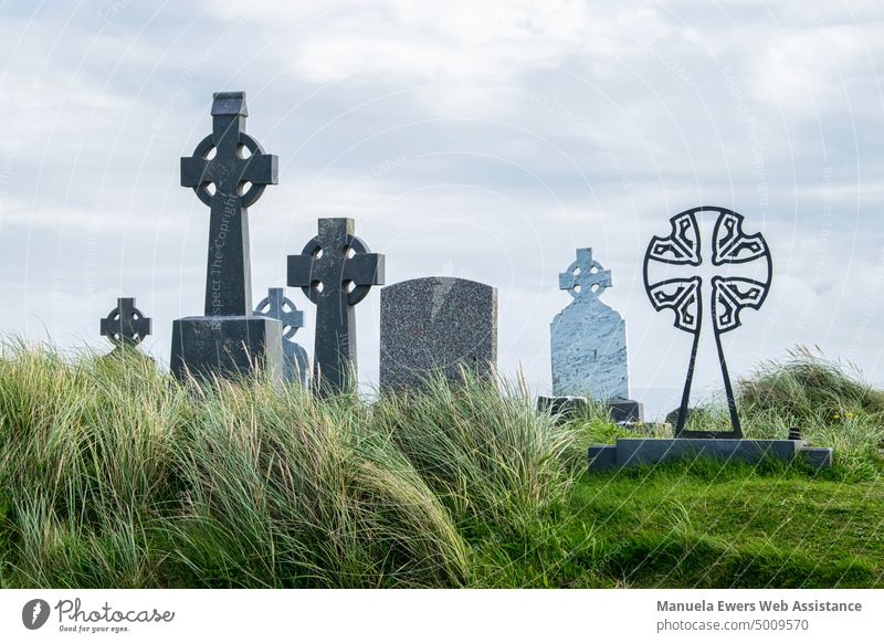Irish gravestones on a grassy hill by the sea Cemetery tombs Ireland Celtic Crosses Meadow Grass tall grass Sky Clouds Ocean Hill Aran Islands