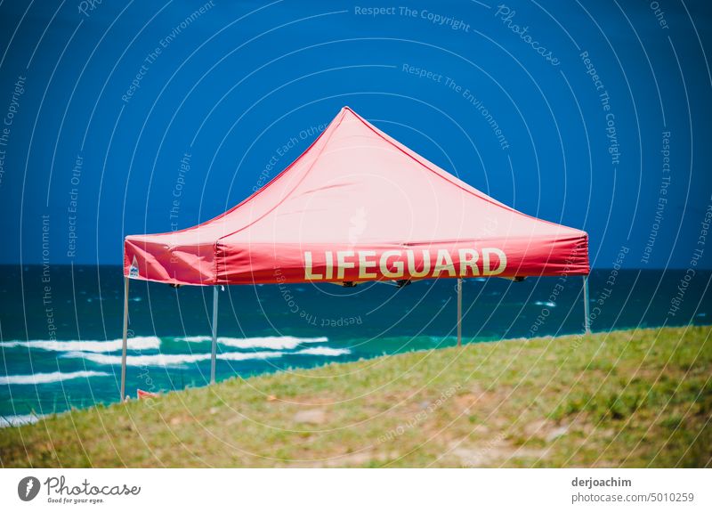 The Steeplechase tent offers protection from sun and rain for the lifesavers at the Pacific. On the red tarp is the writing : LIFEGUARD tent roof Roof Tent