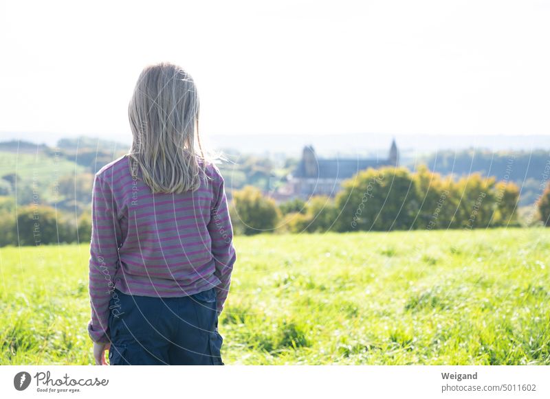 Back view of young girl with gray pink striped sweater looking into the distance at Comburg Castle in Schwäbisch Hall, Germany Girl Landscape Nature