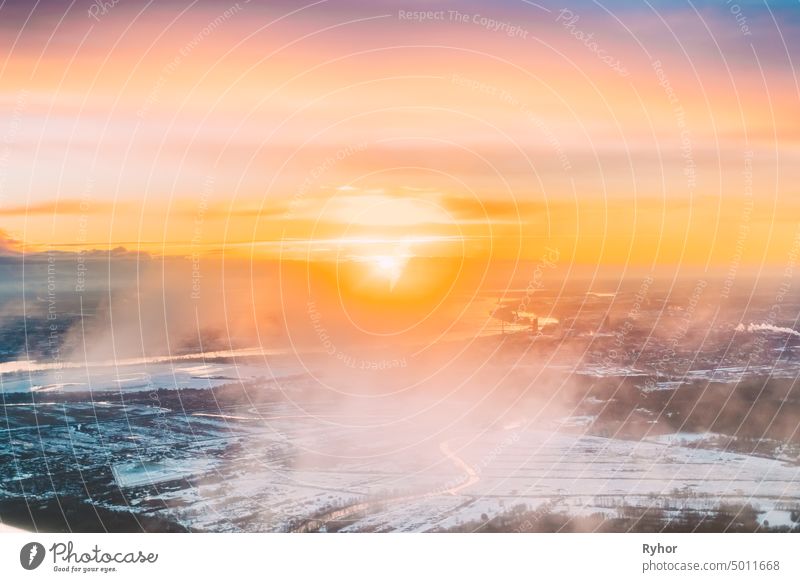 Riga, Latvia. Aerial View Of Sunrise Above City. View From High Altitude Flight Of Aircraft On Latvian Capital In Winter At Sunrise sky birds-eye view drone