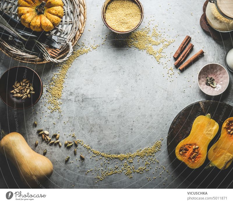 Pumpkin cooking background frame with millet , cinnamon sticks, cardamom and kitchen utensils. Top view pumpkin top view above anise copy space flat lay food