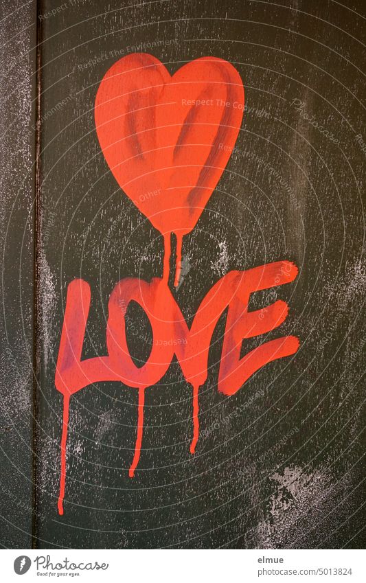 A red heart and LOVE are painted in gradient bright red color on a black wall / love Heart Love Declaration of love Graffiti Emotions Infatuation With love