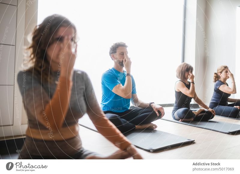 Group of people doing breathing exercise during yoga class mudra practice group gesture wellbeing wellness healthy asana zen lotus pose mindfulness vitality