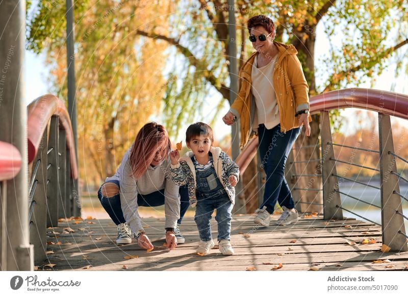 Happy LGBT family having fun in park lesbian couple child play autumn together happy love relationship kid cute cheerful mother women same sex lgbt lgbtq boy