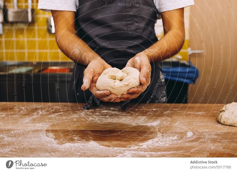 Crop male baker with raw dough in bakery knead man kitchen production prepare chef apron table cook culinary cuisine fresh flour recipe pastry guy uniform
