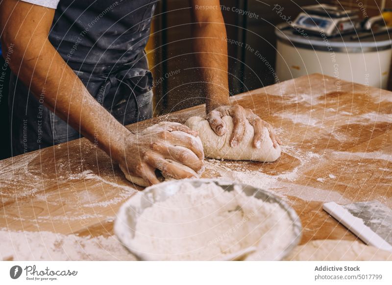 Anonymous man cook shaping dough in bakery process shape prepare table uniform male kitchen food wooden pastry fresh culinary ingredient cuisine professional