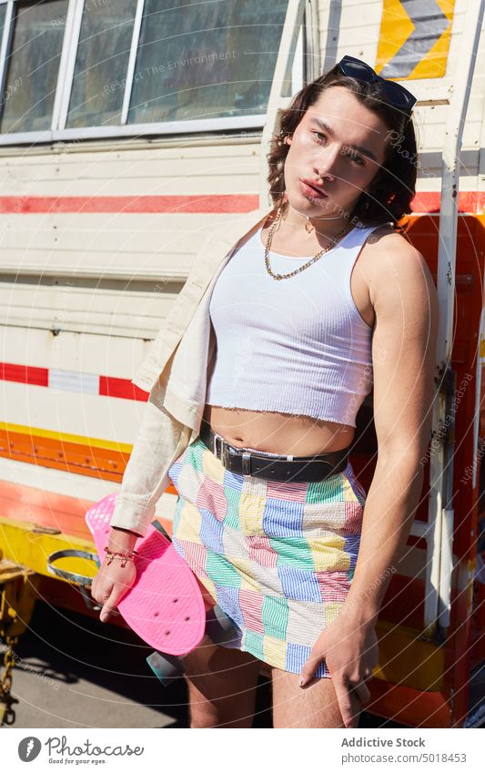 Stylish androgynous man standing near old van queer feminine gay lgbt transgender outfit beautiful homosexual male lean sensual skirt city trendy style urban