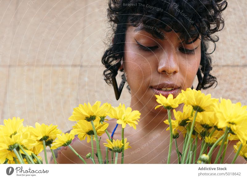 Tender ethnic female in summer clothes standing with bunch of bright yellow chrysanthemum flowers in street woman bouquet bloom tender floral blossom gentle