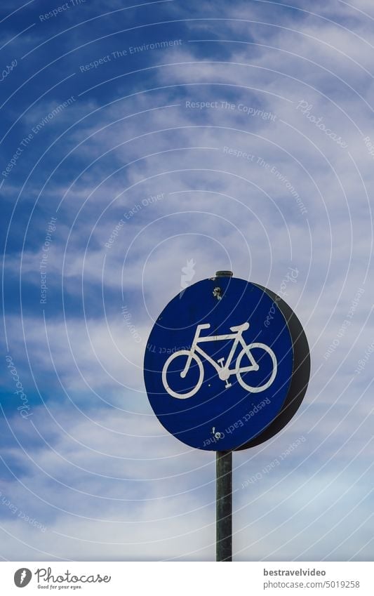 Low-rise day view of bikeway sign under blue sky with clouds. Bikeway sign nobody transportation sign symbol bicycle roadsign track direction europe road sign