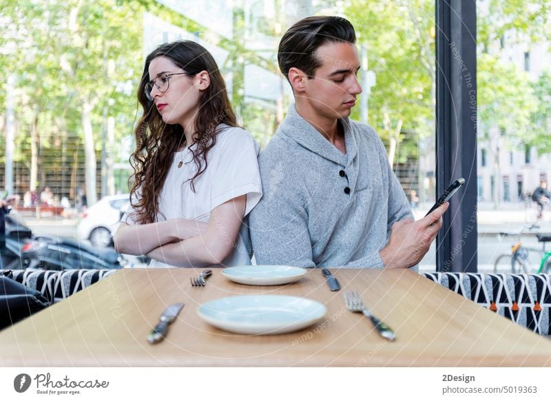 Young woman making an exasperated expression gesture on a bad date at the restaurant couple person cafe angry girlfriend young sitting problem female boyfriend
