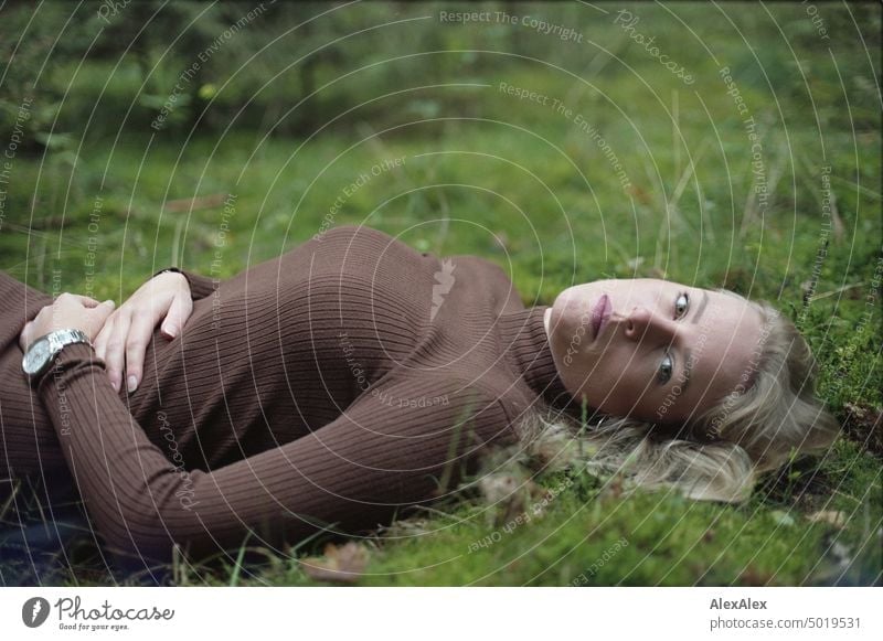 Young blonde woman lying in moss in forest - analog 35mm photo Young woman Woman Blonde Feminine pretty fortunate Youth (Young adults) portrait Adults naturally