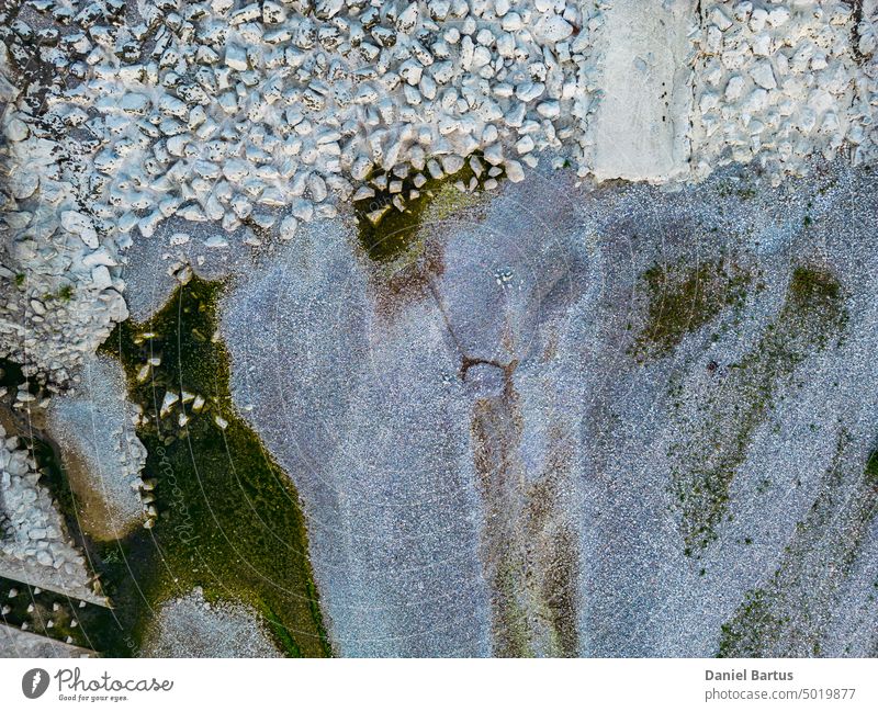The bottom of the dry river with its tributary is visible. Over a small waterfall. Visible stones and water residues. Aerial shot - Background abstract