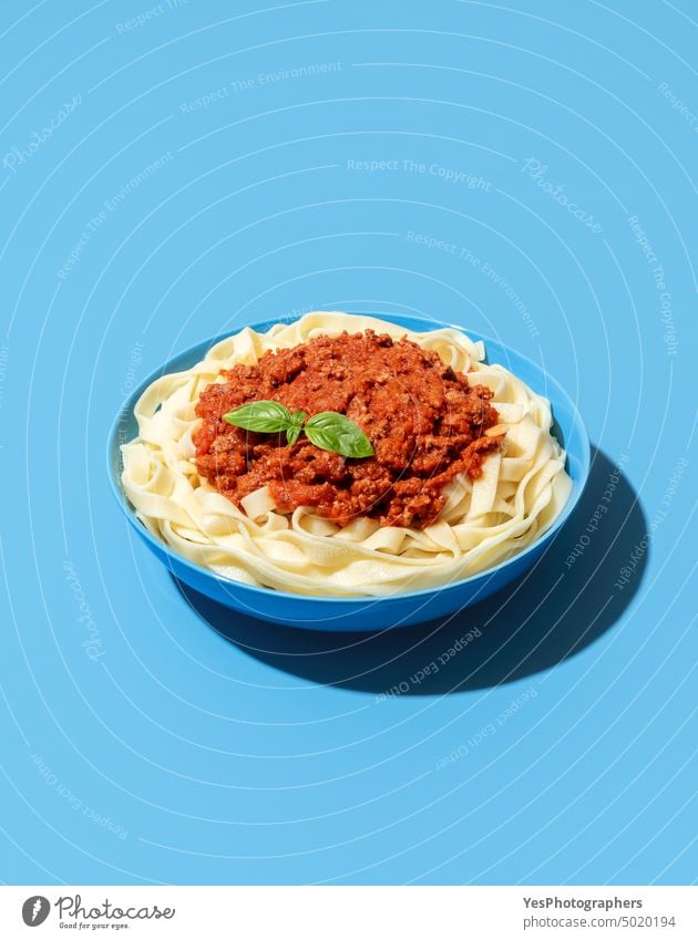 Bolognese pasta dish isolated on a blue background above beef bolognese bowl bright carbs classic color cooked copy space creative cuisine cut out delicious