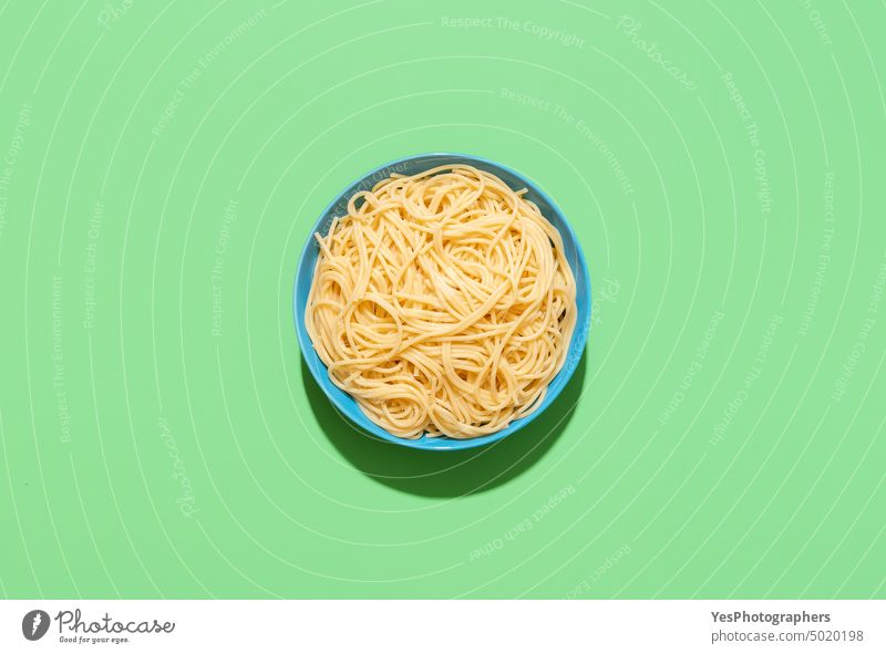 Spaghetti top view on a green background. Cooked pasta without sauce. above blue boiled bowl bright carbs close-up color cooked cooking copy space creative