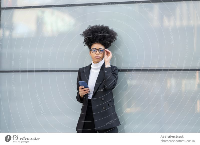 Black woman using smartphone near glass building selfie businesswoman city architect entrepreneur browsing elegant suit chat female ethnic black serious texting