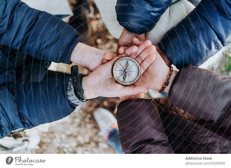 group of children holding a compass hand male young person nature tourism background explore view tourist cropped people white travel one blue landscape