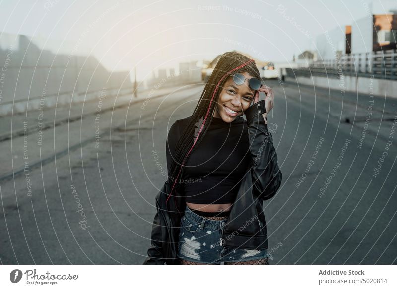 Smiling black woman on road city street smiling stylish young lifestyle leisure female trendy casual town urban asphalt shabby grungy cheerful joy lady
