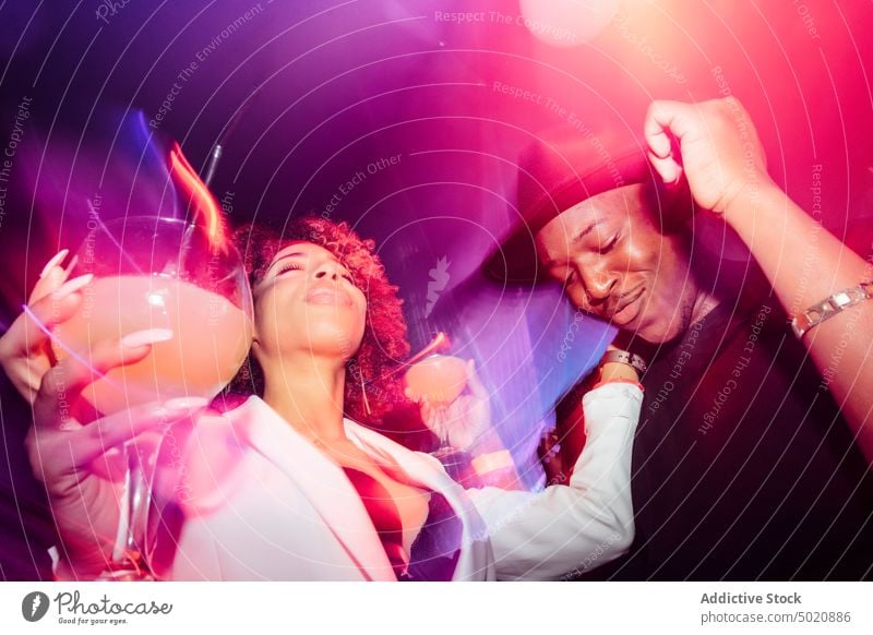 Black couple dancing under colorful light dance fun party nightclub scream ethnic illuminate neon man woman yell shout black african american nightlife bright