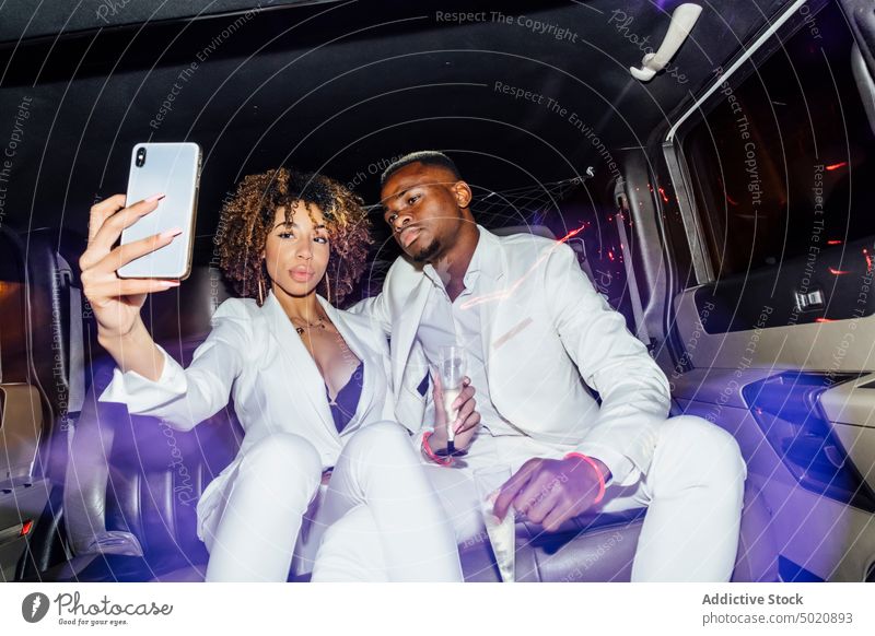 African American couple taking selfie in limousine party nightlife smartphone champagne fancy together ethnic ride man woman african american black gadget