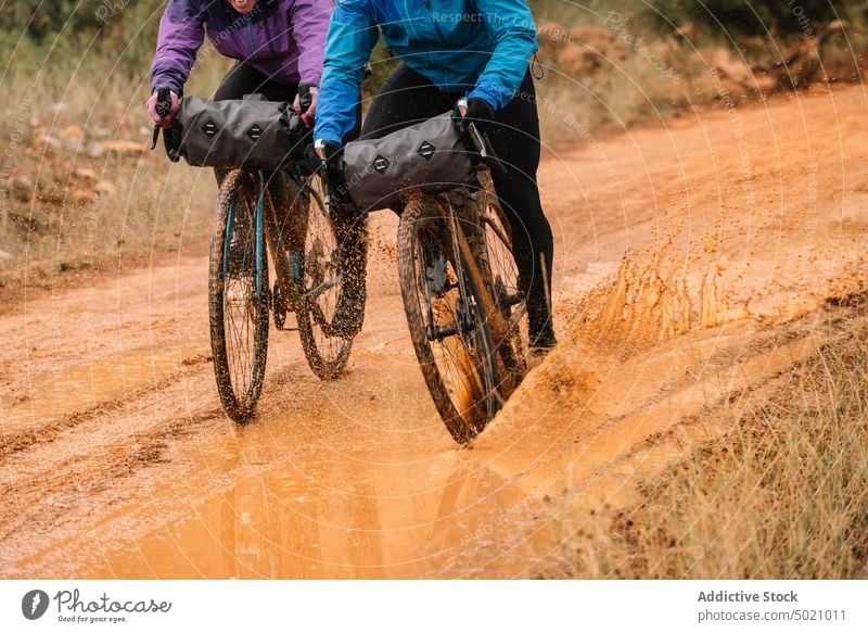 Well-equipped people on road in forest during bike trip adventure bicycle active nature helmet cyclist sport lifestyle speed ride recreation healthy countryside