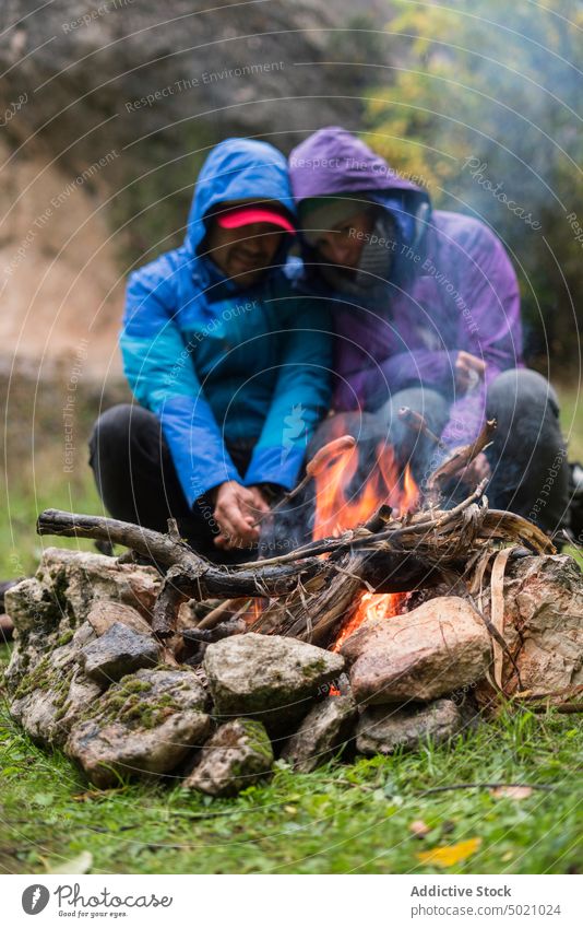 People in warm wear sitting by fire and frying sausages people bike flame adventure together bicycle heat friendship active protective fireplace nature hide