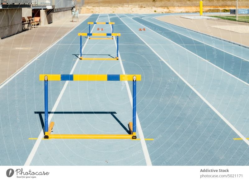 Colorful hurdles on blue racetrack stadium training track and field sport activity colorful equipment professional vitality wellness workout barrier power