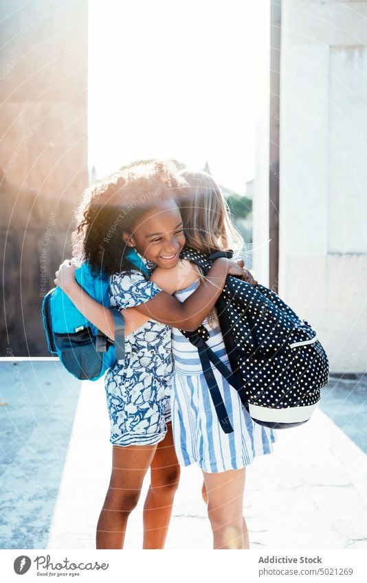 Multiracial joyful girls hugging in sunlight embrace best friend bonding happy children multiethnic african american together diversity multiracial having fun
