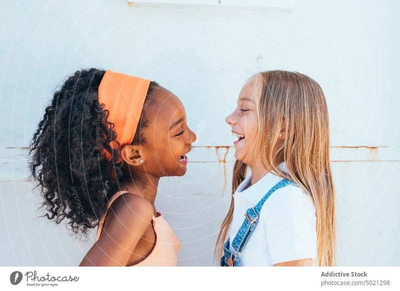 Cheerful African American girl with best friend having fun near white wall children happy smiling together diverse cheerful multiethnic black african american