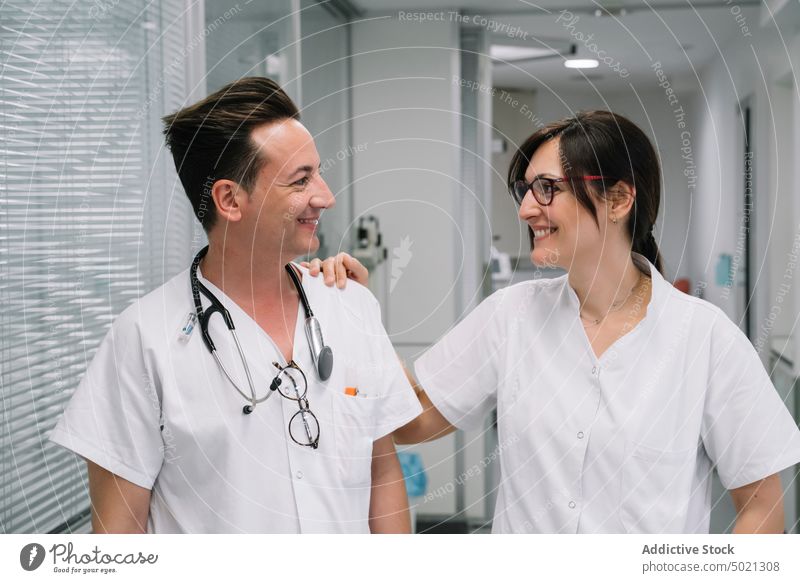 Happy pediatricians standing in hospital corridor medical treatment healthcare cure work professional doctor nurse young people smiling cheerful happy carefully