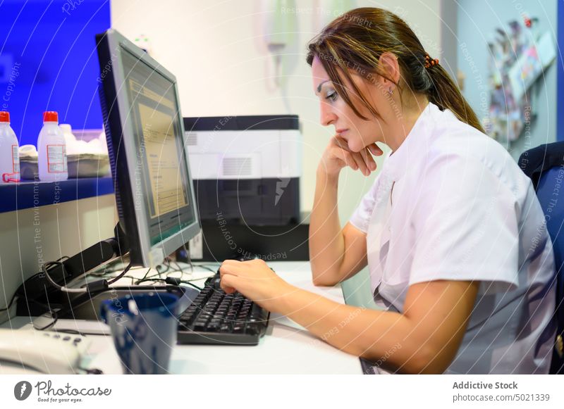 Tired doctor using computer in hospital tired woman work lab uniform medical healthcare female adult exhausted fatigue overworked occupation busy monitor