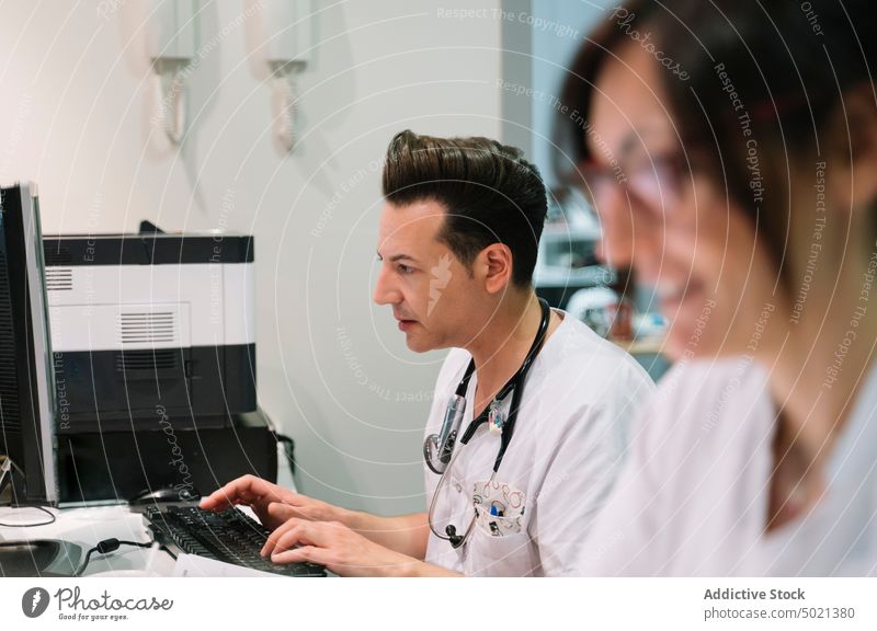 Doctor working at computer doctor hospital device medical digital modern treatment healthcare man cure technology nurse carefully professional attentively