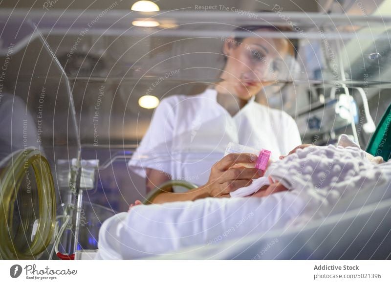 Nurse feeding baby in incubator hospital nurse care premature work medical infant treatment therapy patient neonatal health clinic help sterile reanimation