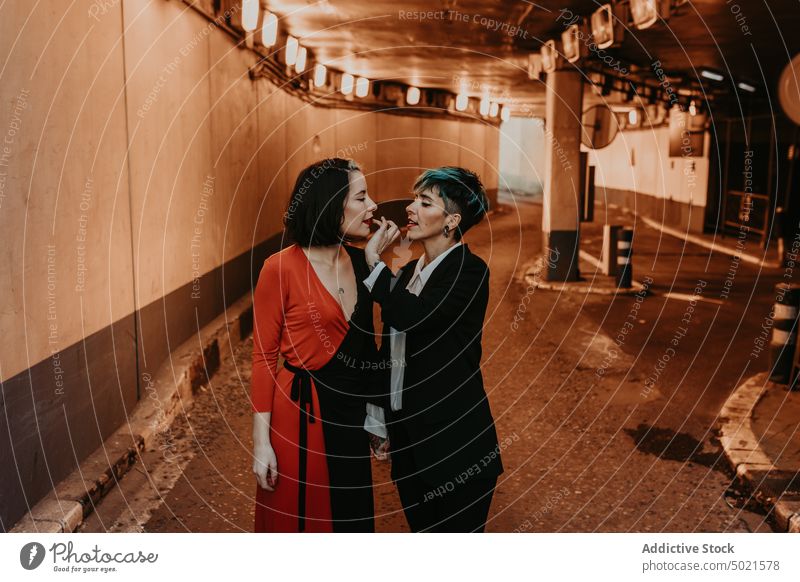 Young women having a romantic moment on tunnel lesbian couple street embracing kissing stylish tattoo holding hands love young walkway happy cheerful subway