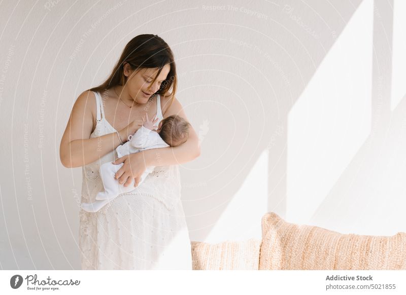 Mother carrying baby in arms mother hug sleep love childcare tender calm affection woman press chest together embrace peaceful gentle eyes closed touch relax