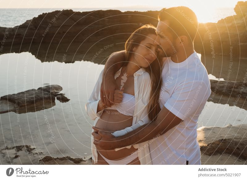 Pregnant couple standing near sea at sunrise pregnancy together love coast relationship man thoughtful woman shore pregnant countryside holding hands tender