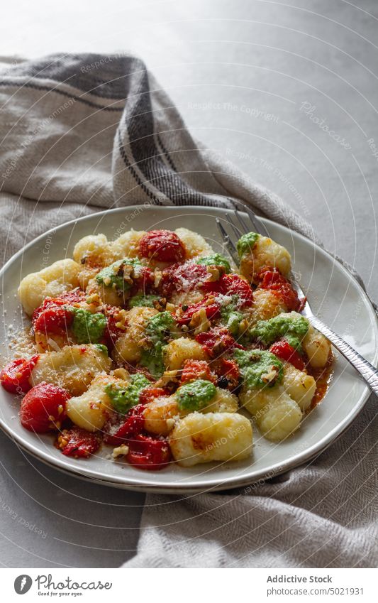 Delicious gnocchi with tomato pesto pasta dish plate table kitchen napkin fork food meal fresh tasty delicious vegetable organic healthy ingredient dinner lunch