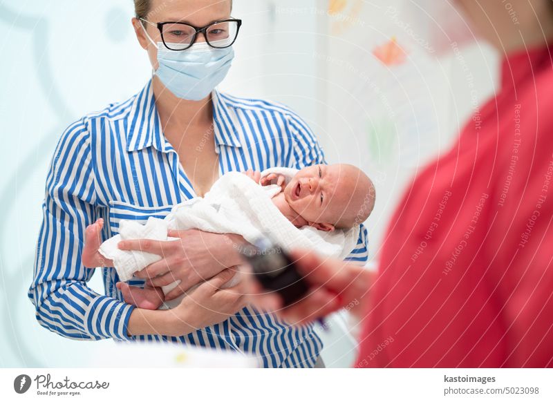 Mother holding her baby boy at medical appointment at pediatrician office. parent consultation consulting medicine stethoscope care mother child doctor visit